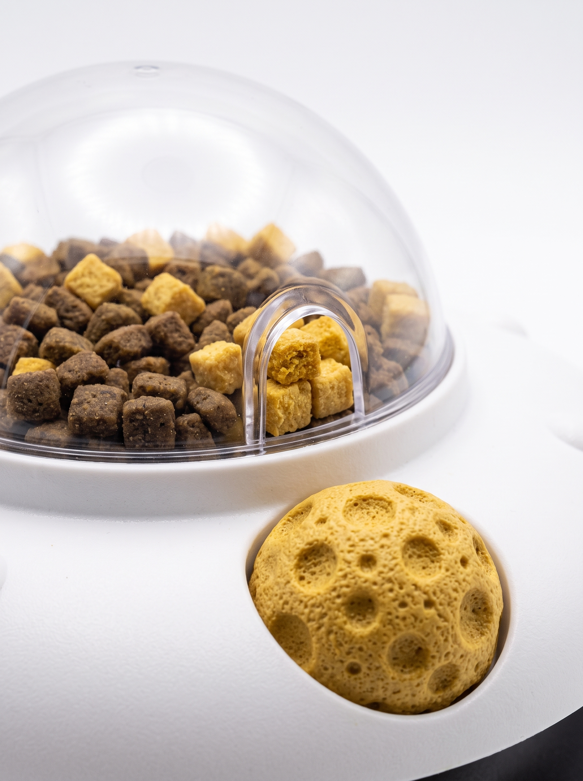 Close up of the clear dome and yellow side ball on the treat dispenser